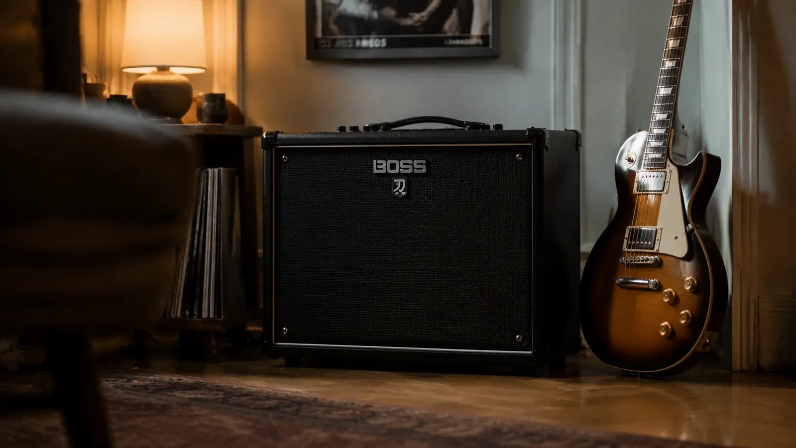 Boss Katana 50 MkII combo amp sitting on a wooden floor in a warmly lit home practice room, guitar leaning against the wall beside it