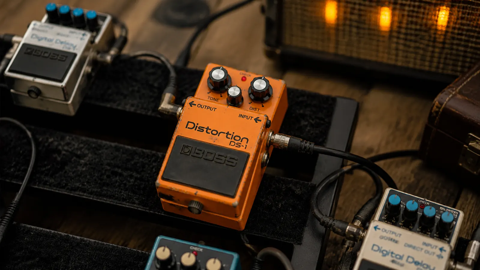 Side-by-side of a Boss DS-1 next to a Fulltone OCD and a Ibanez Tube Screamer on a studio workbench